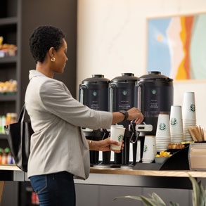 black woman dispensing brewed coffee at self-serve station