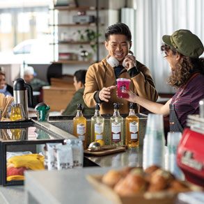 barista handing man Mango Dragonfruit Refresher beverage